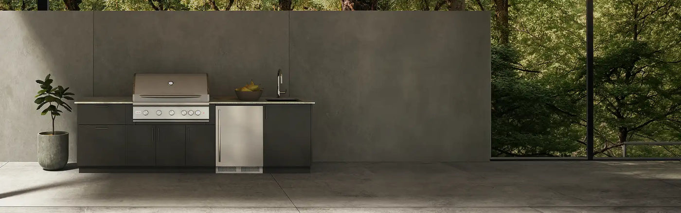 Modern minimalist outdoor kitchen in Houston featuring a premium Blaze built-in gas grill, dark cabinetry, and an outdoor refrigerator set against a concrete wall.