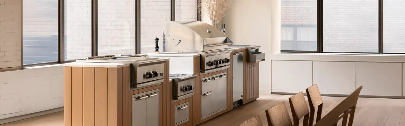 Modern organic outdoor kitchen island featuring a premium DCS built-in gas grill and stainless steel cabinetry in Houston.