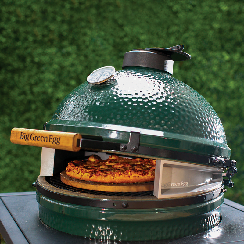 Big Green Egg cooking pizza at high temp with the Pizza Wedge, available at Texas Star Grill Shop with free assembly & delivery - Houston's #1 Big Green Egg Kamado Grill Dealer
