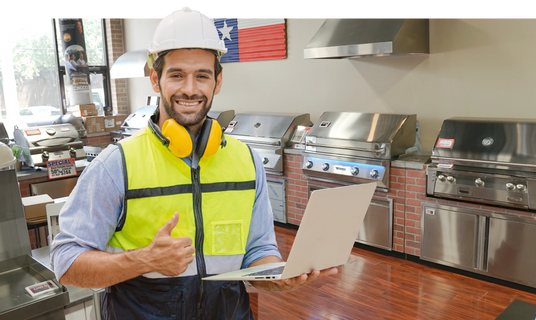 contractor standing in outdoor kitchen section of texas star grill shop with a smile and thumbs up
