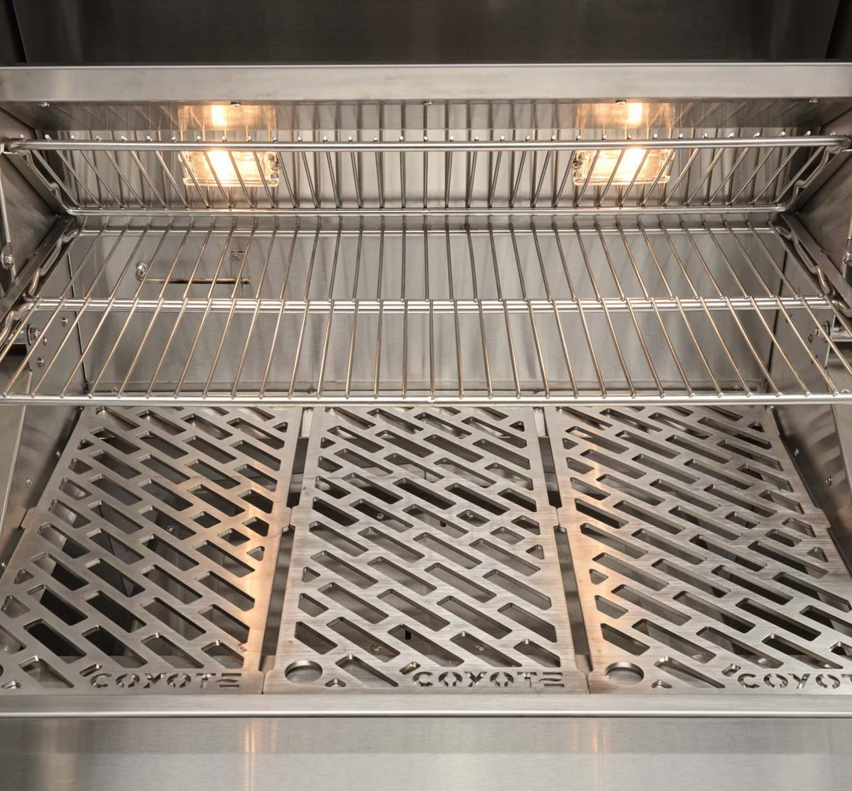 Interior cooking grates with lights on inside the Coyote 28-Inch Pellet Grill