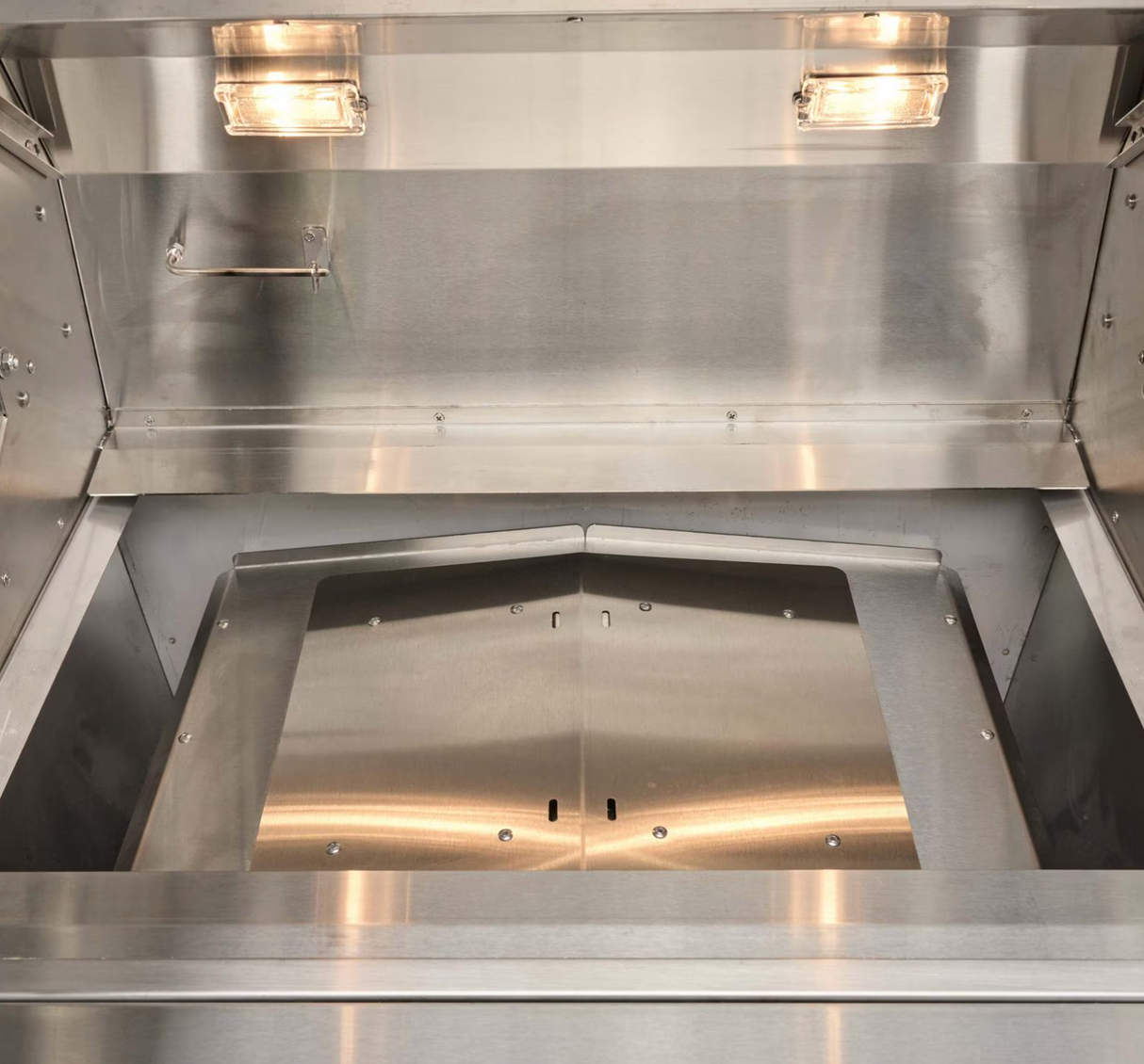 Heat deflector plate under the cooking grates in Coyote pellet grill