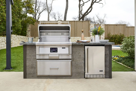 Coyote 36" pellet grill installed in a modern outdoor kitchen with the lid open.