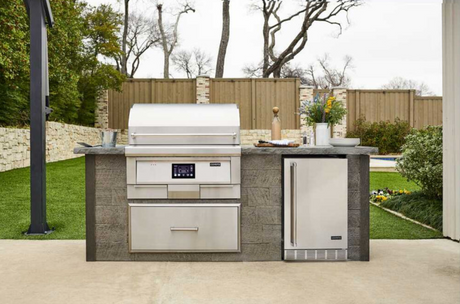 Coyote 36" pellet grill installed in a modern outdoor kitchen with the lid closed.