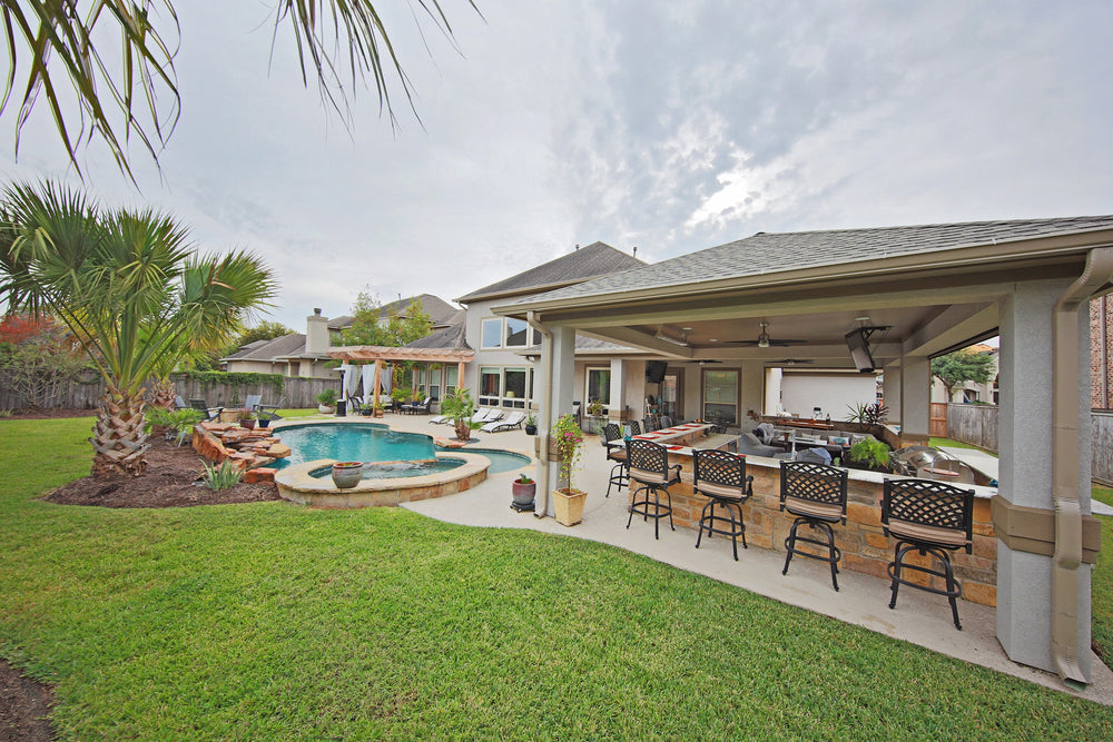 Covered outdoor kitchen, pool, and spa by EcoWorks Pool & Outdoors