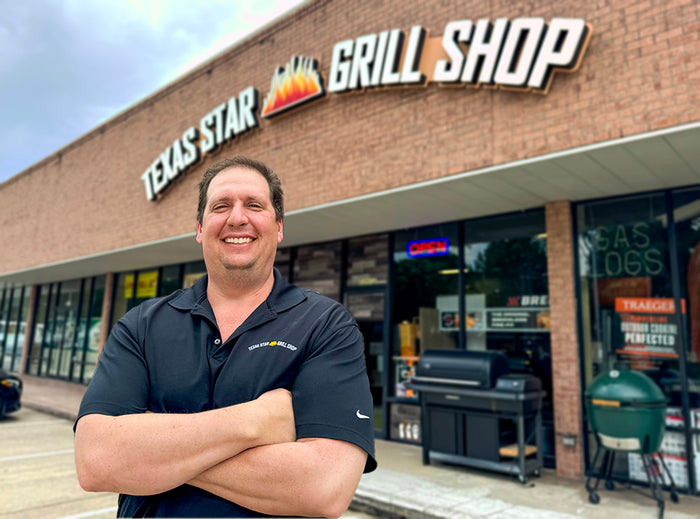 Texas Star Grill Shop Katy storefront with employee posing confidently