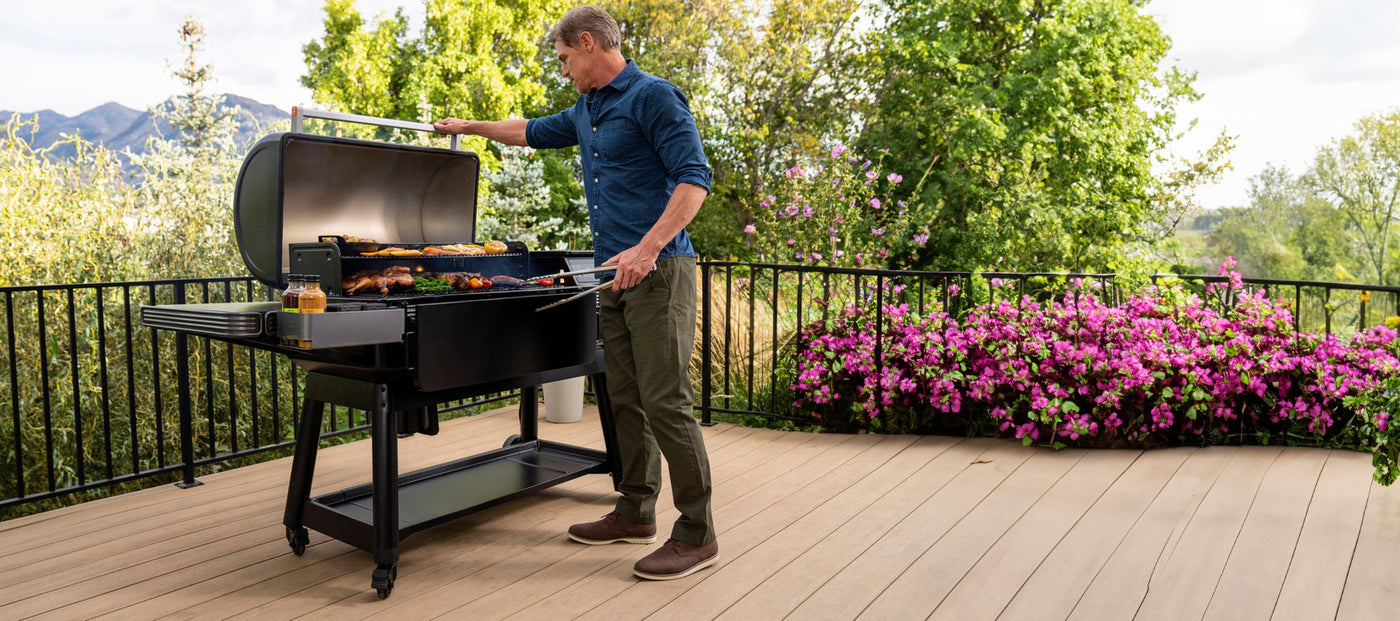 man grilling bbq on a Traeger Ironwood XL wood pellet grill from Texas Star Grill Shop during their spring grill sale