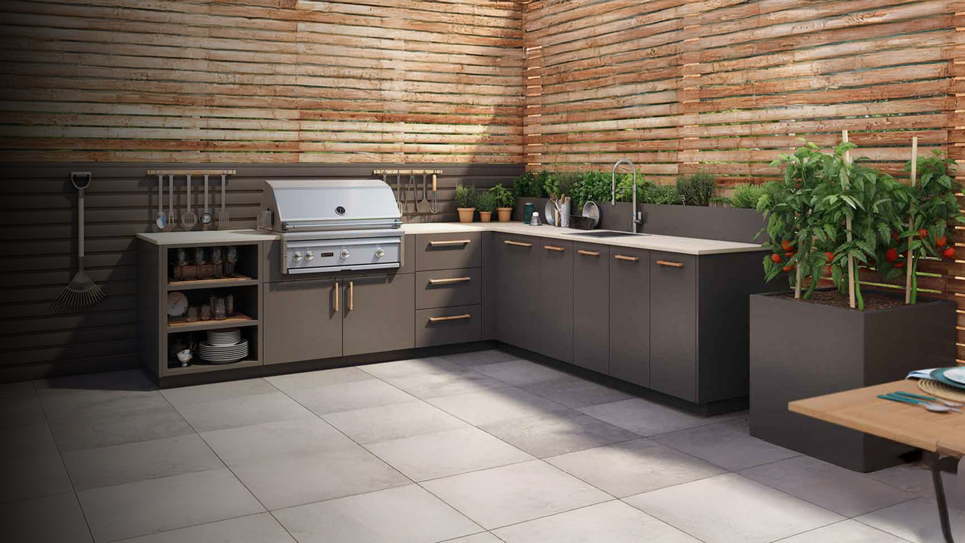 Modern Urban Bonfire outdoor kitchen with integrated stainless steel grill, sleek cabinetry, countertop herbs, and fresh tomato plants in a corner patio setup.