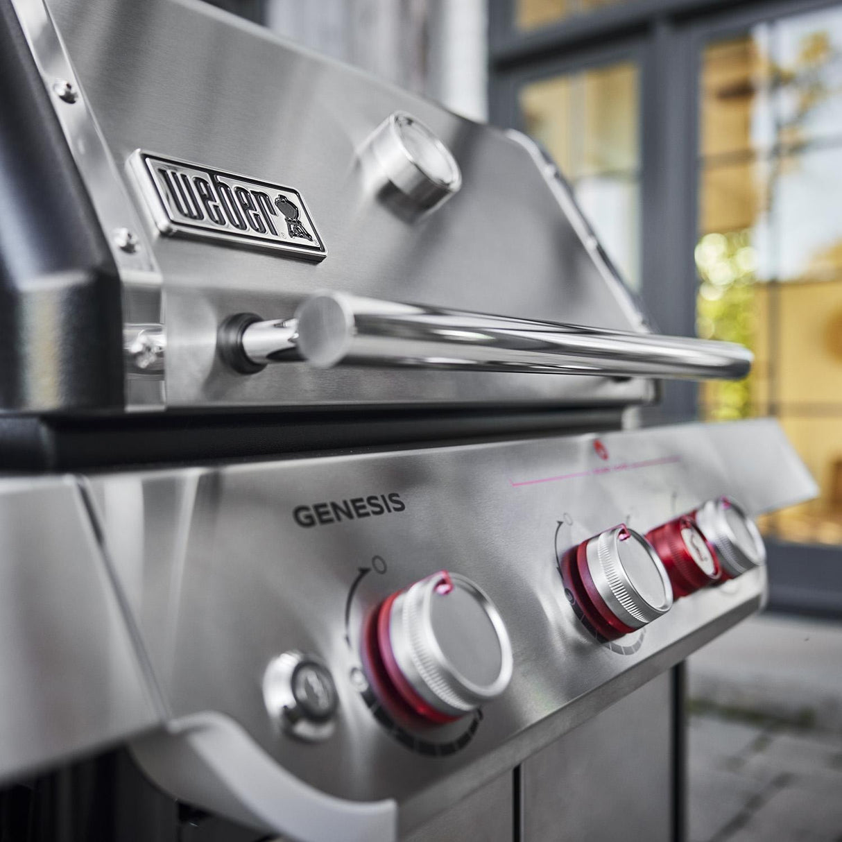 Close-up of the Weber Genesis SP-S-325 stainless steel control panel with red sear zone knob