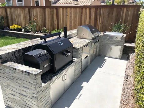 Yoder Smokers YS640s built-in pellet grill installed beside another grill in a custom outdoor kitchen